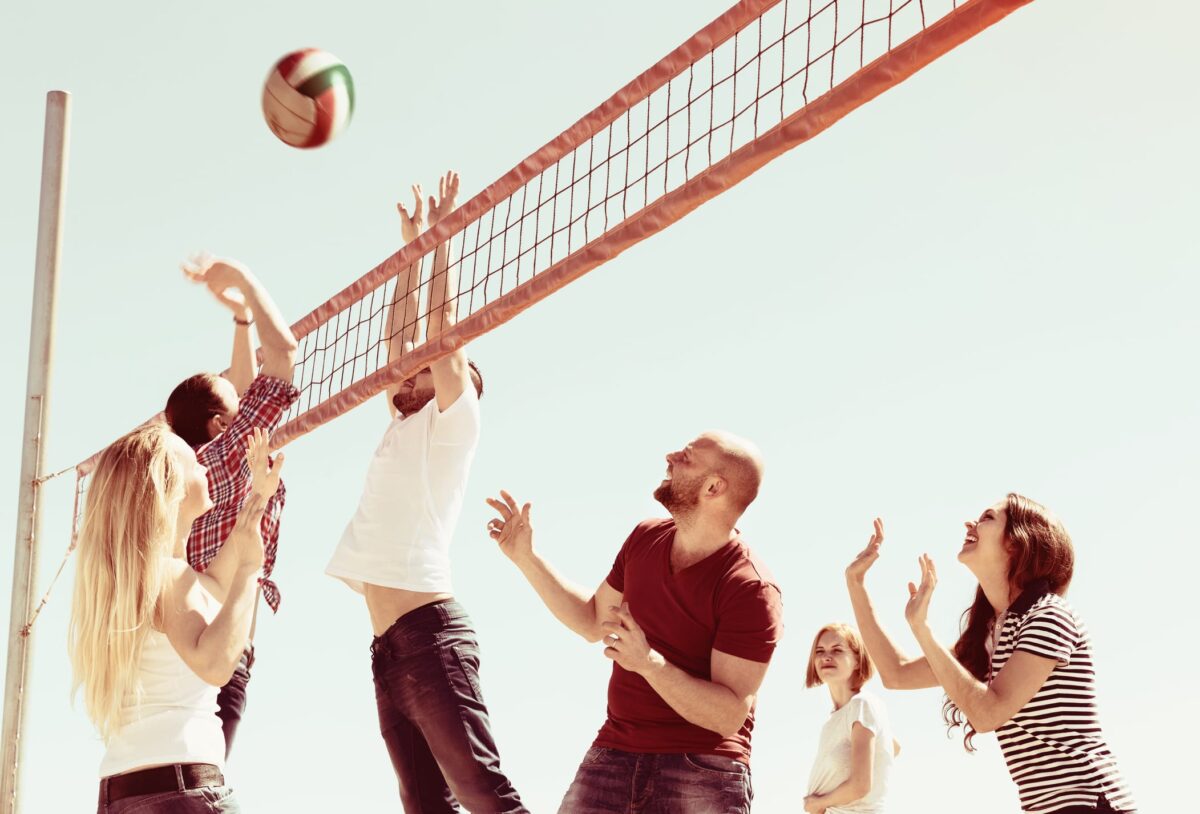 group of people playing volleyball outside