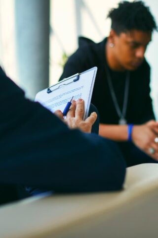 young man sitting across from a clinician undergoing a substance abuse evaluation