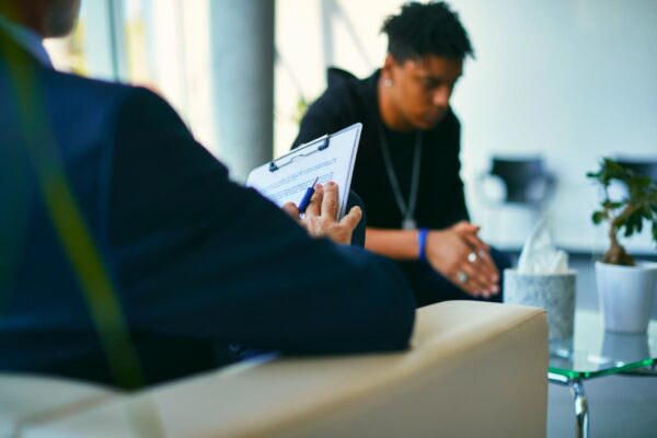 young man sitting across from a clinician undergoing a substance abuse evaluation