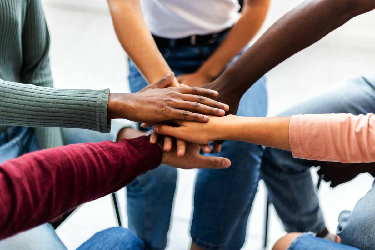 image of hands meeting together for teamwork in group therapy for mental health and addiction